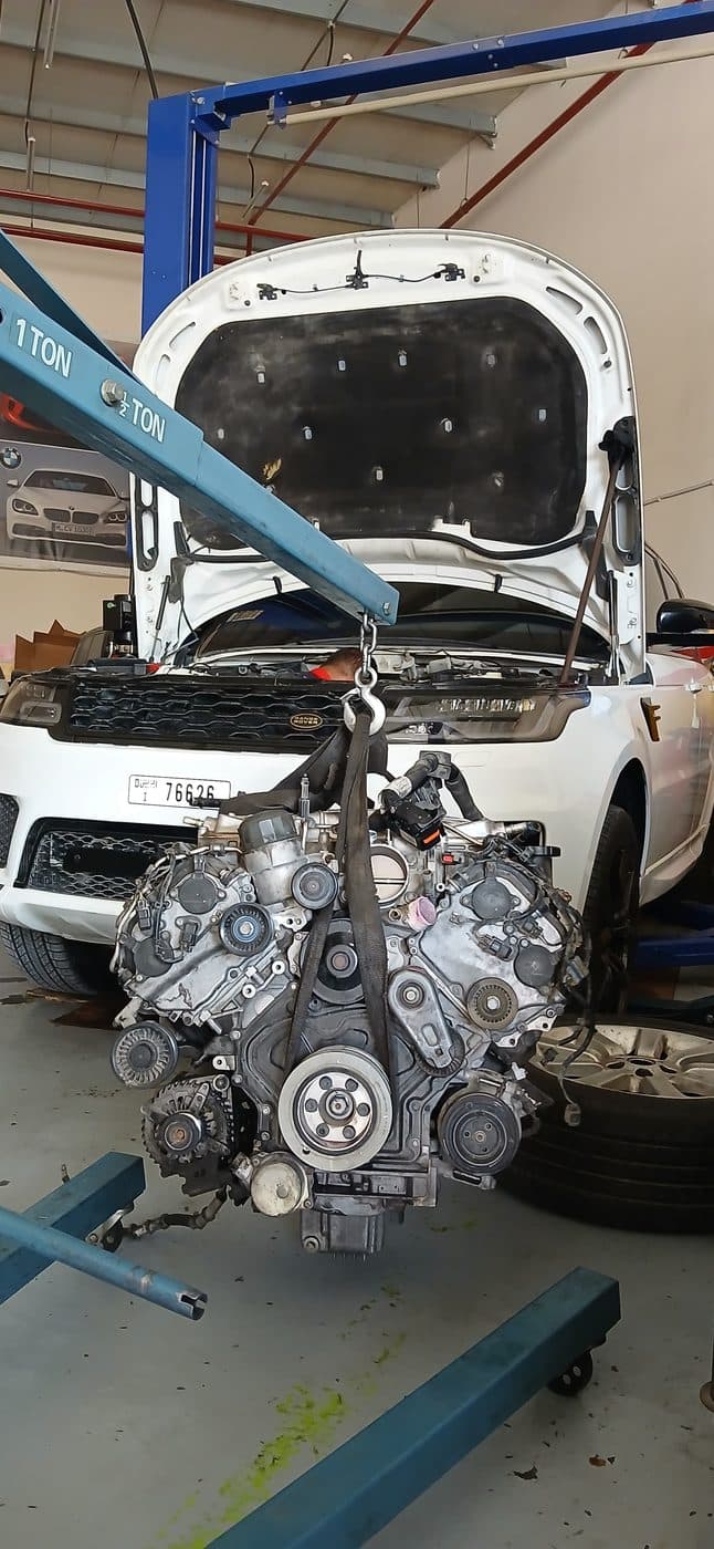 An engine lifted out of a vehicle on a hoist during an overhaul at the GAS AUTO workshop